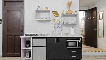 A modern kitchen with a built-in oven, a coffee maker, and a refrigerator.