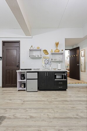 A modern kitchen with a built-in oven, a coffee maker, and a refrigerator. - Casa Of Essence (San Juan)