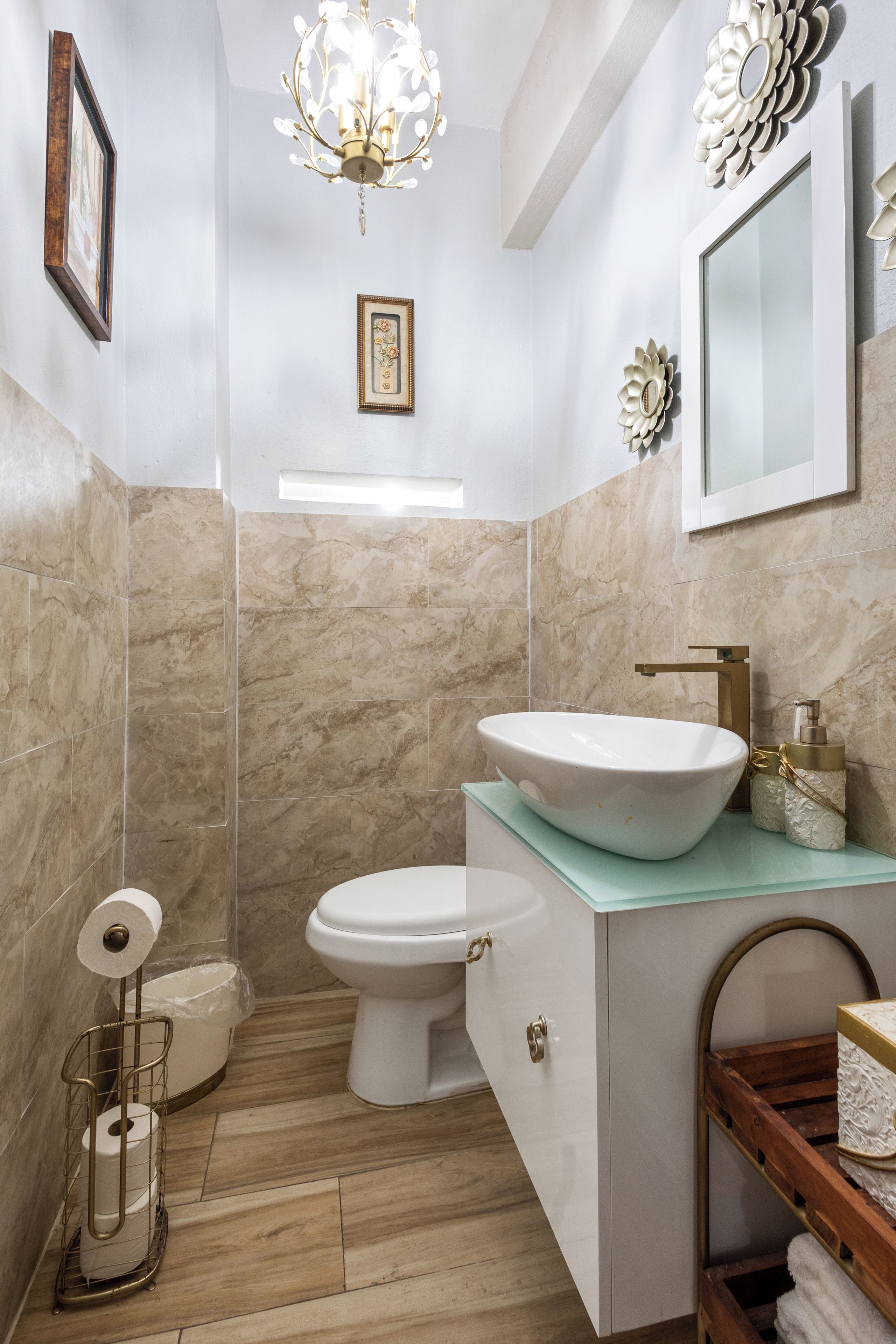 Un baño con lavamanos, inodoro y zona de ducha blanca.