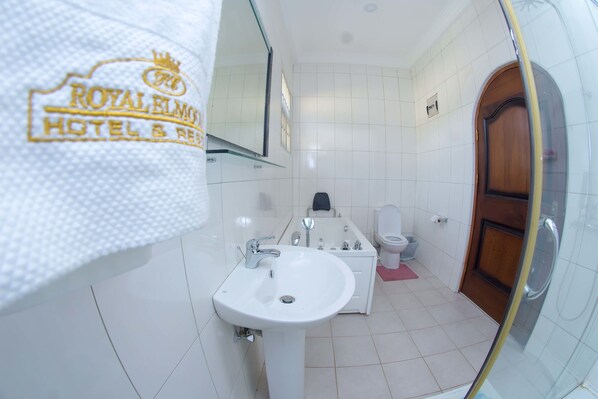 A bathroom with a white sink, mirror, and toilet. - Royal Elmount Hotel (Elmina)