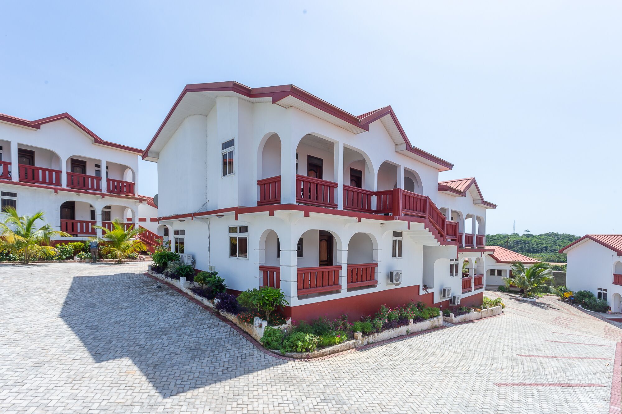 A multi-story hotel with red balconies and white walls.