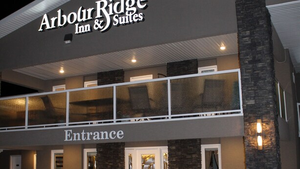 A hotel entrance with a sign reading "Arbour Ridge Inn & Suites." - Arbour Ridge Inn & Suites (Kindersley)