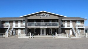 A two-story building with a sign reading "Arbour Ridge Inn & Suites" and an "Entrance" sign. - Arbour Ridge Inn & Suites (Kindersley)