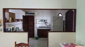 Eine kleine Küche mit Kühlschrank, Spüle und Schränken.