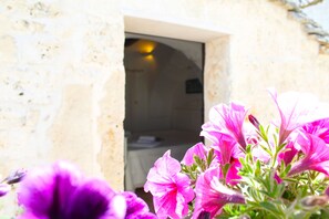 A stone building entrance with a doorway leading inside. - Trulli Antica Fonte (Alberobello)