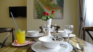 A dining table set with white plates, bowls, cutlery, and a glass of orange juice. - Nyali Parkside Resort (Mombasa)