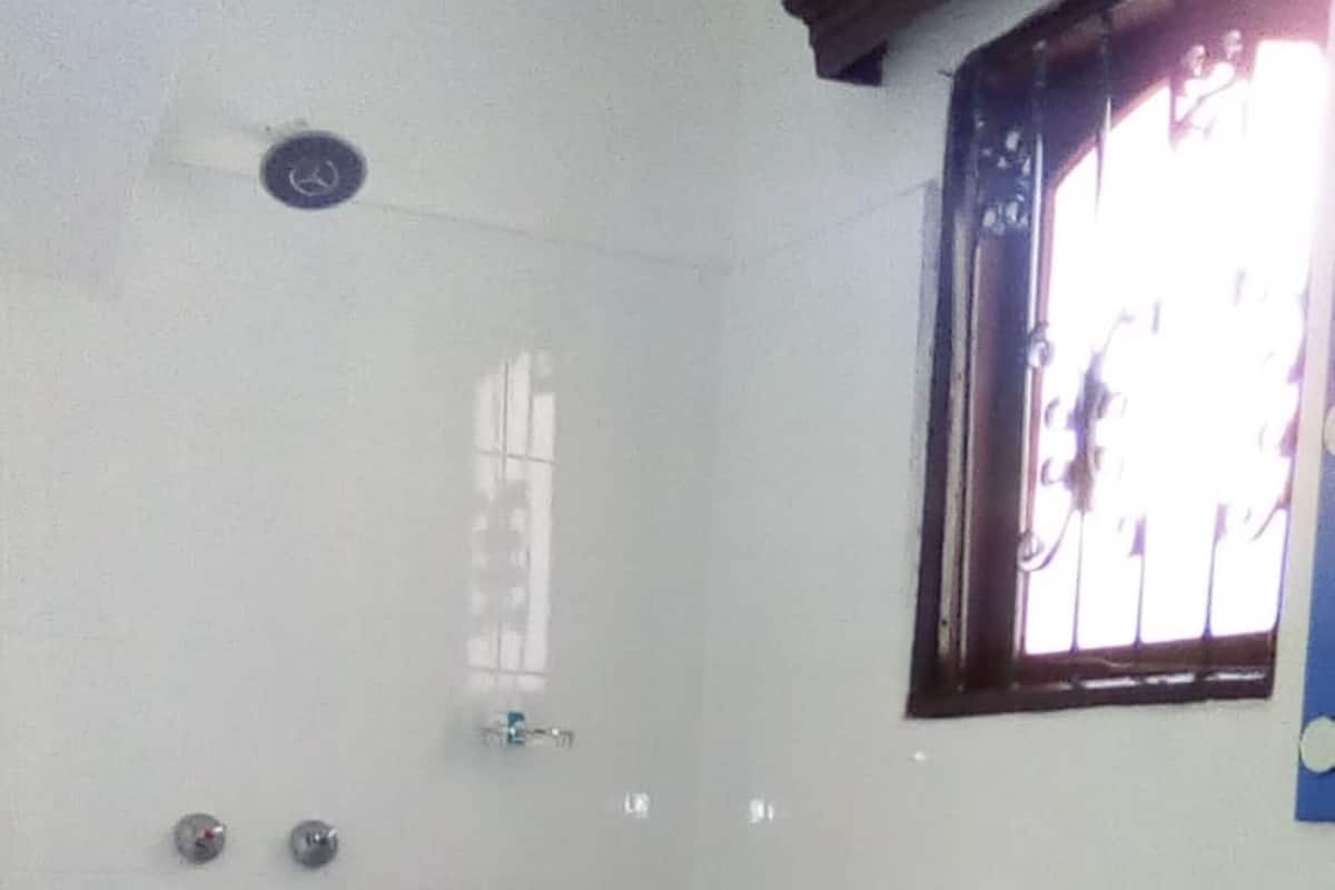 A small, basic bathroom with a toilet, sink, and window.