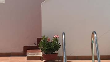 Una piscina al aire libre, sillones reclinables de piscina