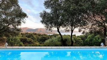 Una piscina al aire libre de temporada, tumbonas