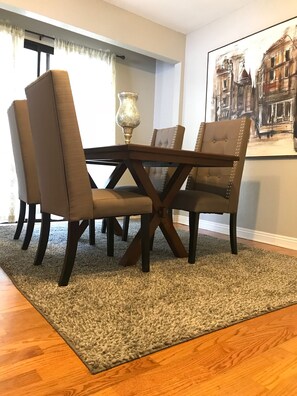 Enjoy meals in this stylish dining area with a cross-back dining table and tufted chairs.