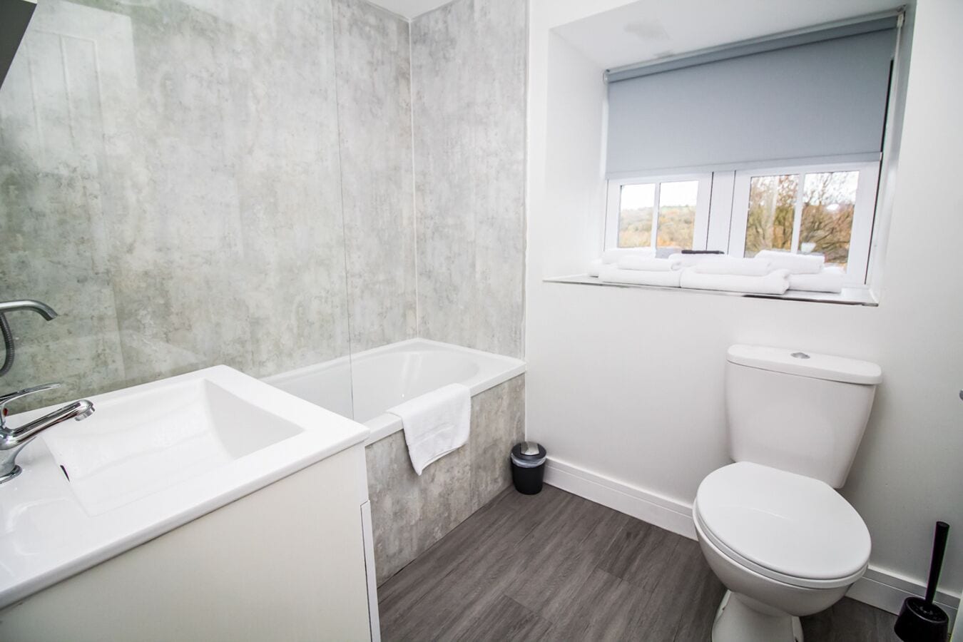 A modern bathroom with a bathtub, sink, and toilet.