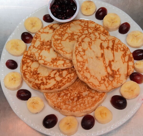 A plate of pancakes with cherries and banana slices.