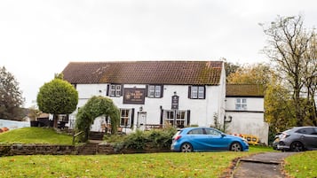 Un edificio blanco tradicional con un letrero que dice 'The Saxon Inn Free House'.