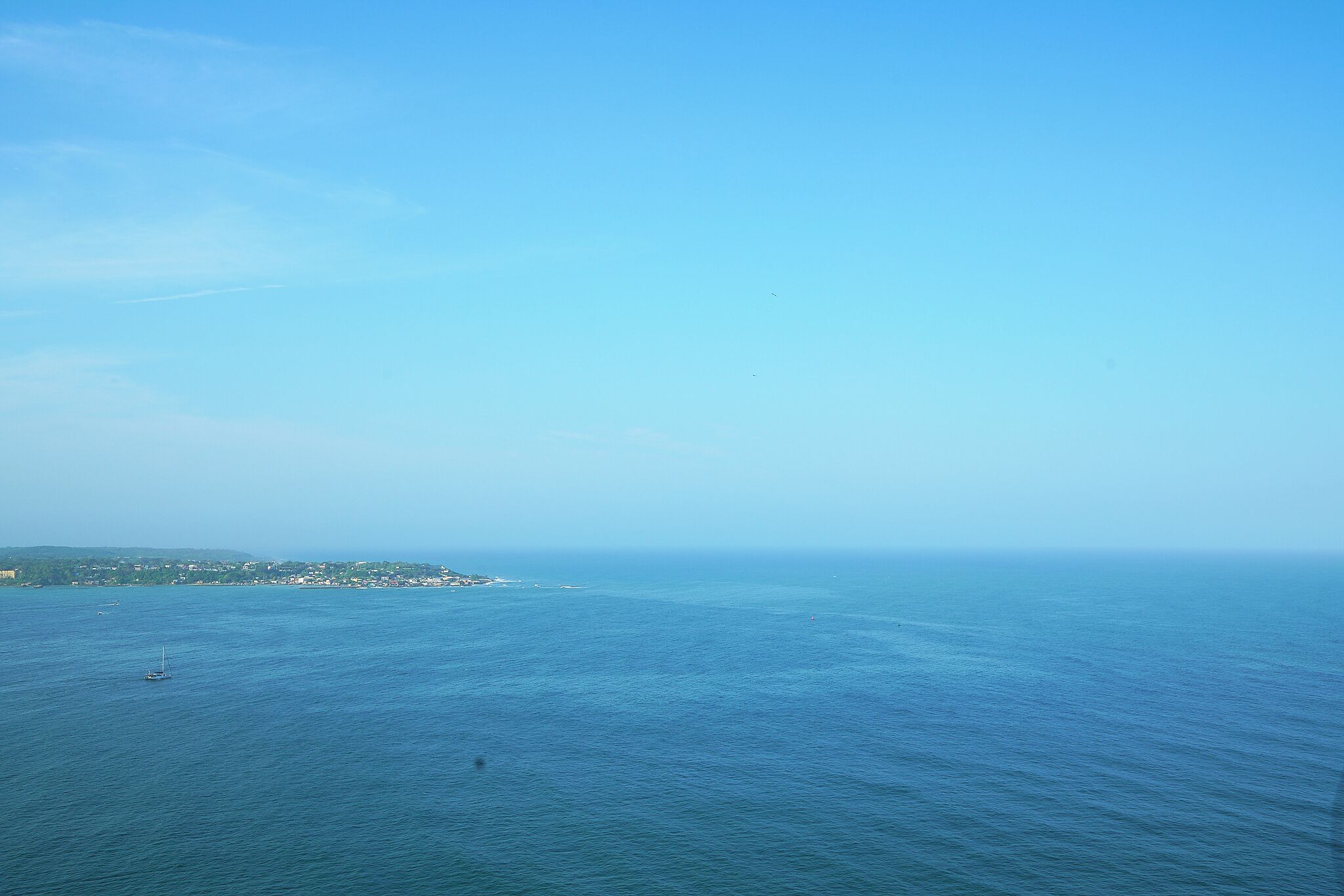 A coastal view with a clear sky and calm sea.