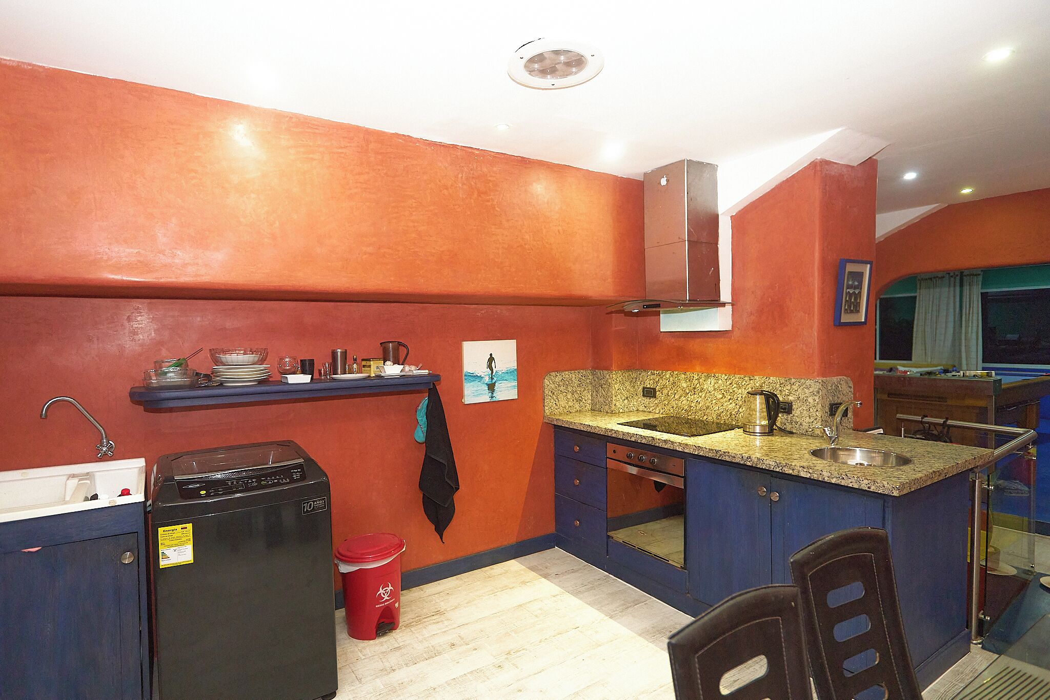 Cocina compacta con lavavajillas, fregadero y estufa.