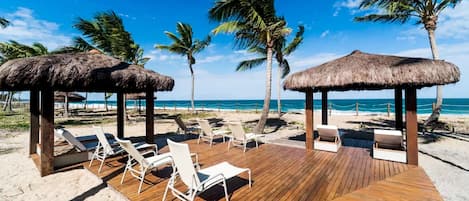 On the beach, white sand, sun loungers, beach umbrellas