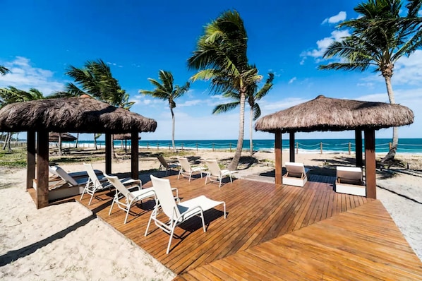 Plage, sable blanc, chaises longues, parasols