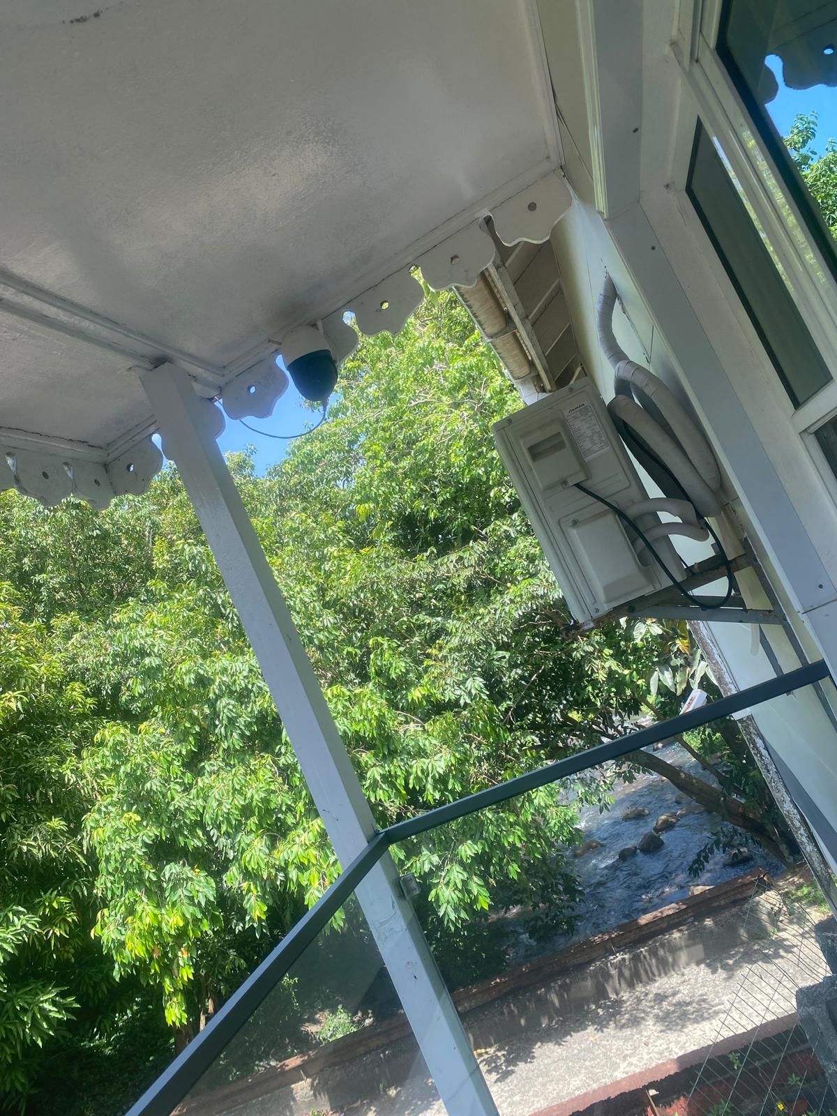 Un balcón con vistas a árboles verdes y un cielo despejado.