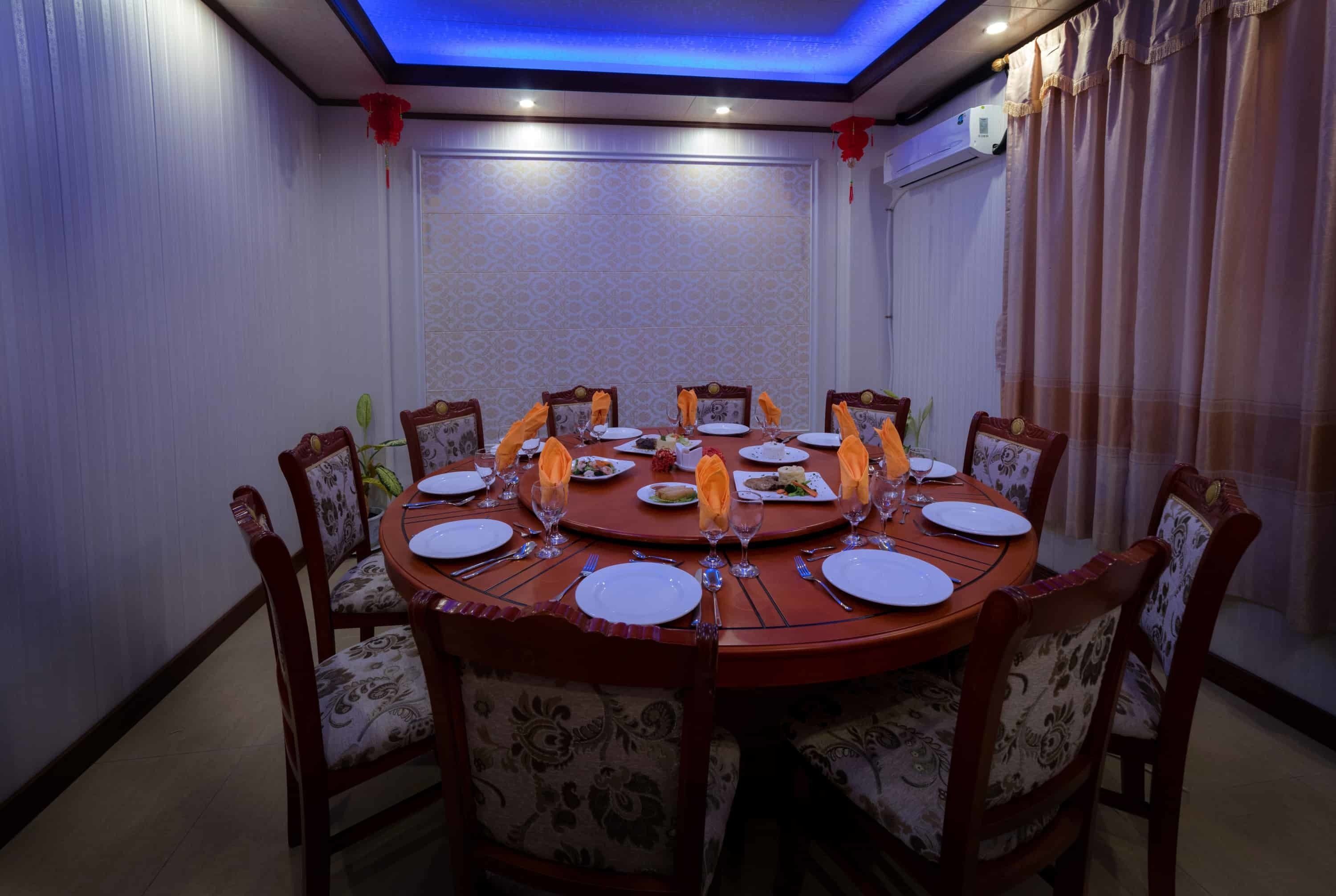 Mesa de jantar redonda com cadeiras, posta para refeição.