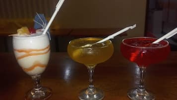 Trois verres posés sur le comptoir d’un bar, accompagnés d’un dessous de verre orné d’un motif représentant un lion.