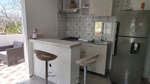 A compact kitchen with a refrigerator, a sink, and a window. - Caribbean Sea Breeze (San Andrés)