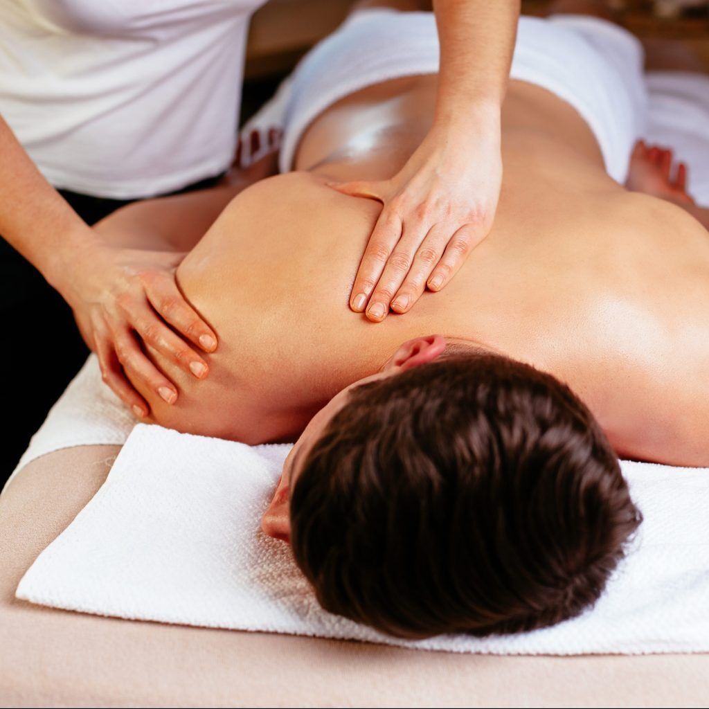 A person receiving a back massage on a white towel.