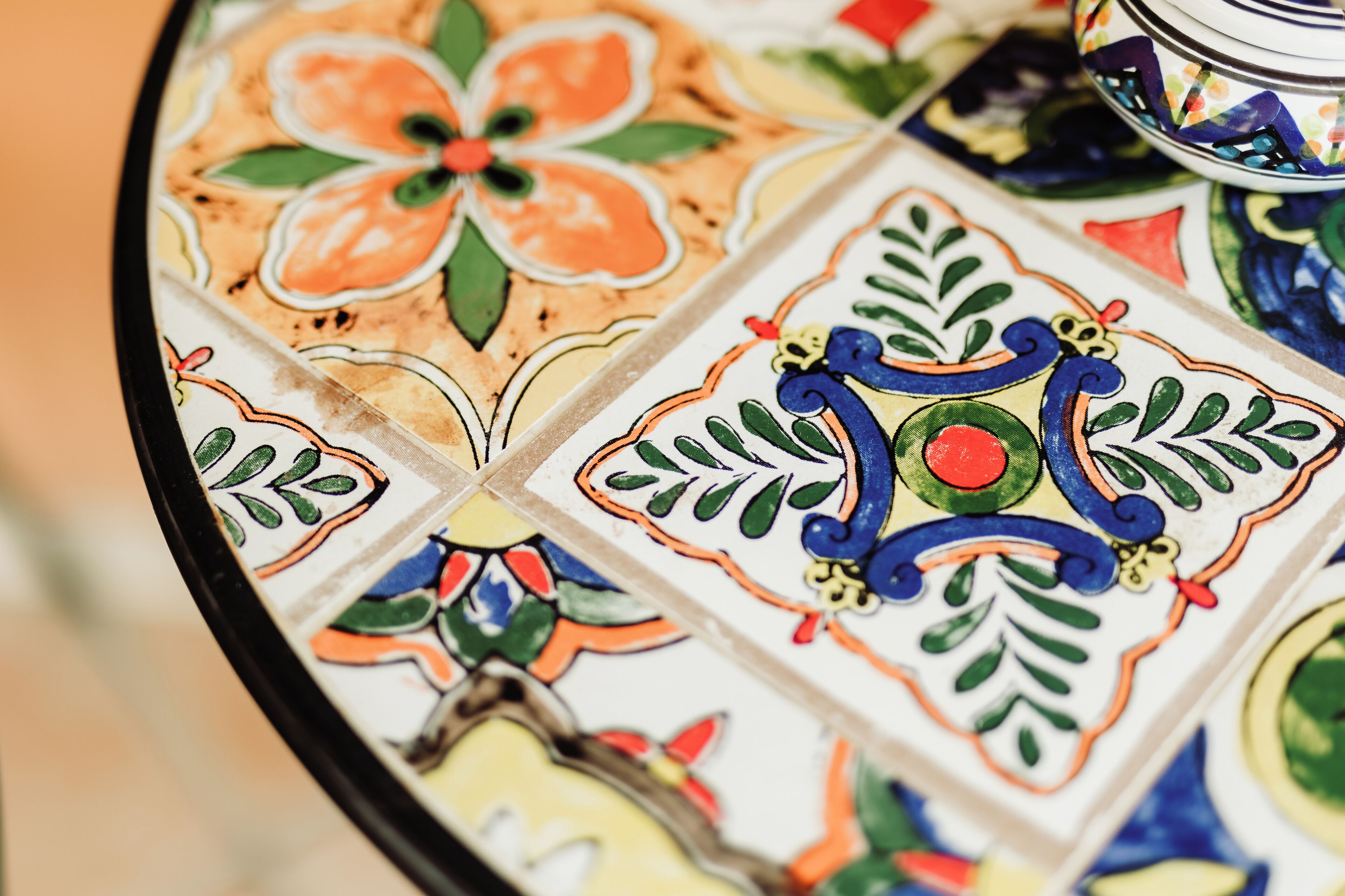 A close-up of a colorful tile with a floral pattern.