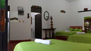 A room with two single beds, a wooden bunk bed, a mirror, a small table, and a lamp. - Hospedaje el Mirador (Villa de Leyva)