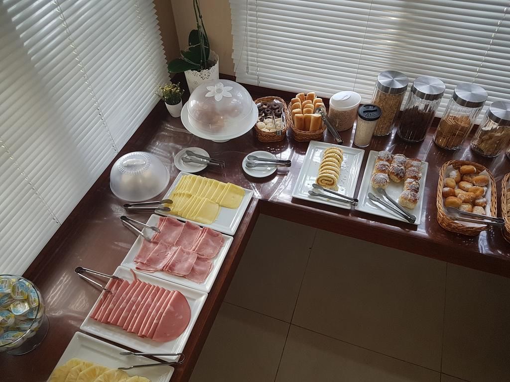 Buffet com diversos alimentos, incluindo carnes, doces e acompanhamentos.