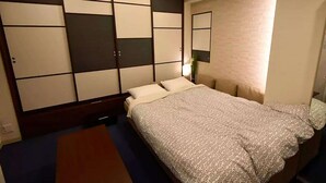 A hotel room with a bed, a wooden headboard, a nightstand, and a mirror on the wall.