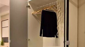A walk-in closet with a hanging rod and shelves.