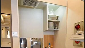 A compact kitchen with a built-in stove, a sink, and a small refrigerator.