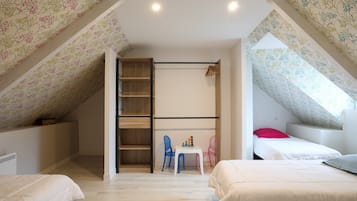 Un dormitorio con zona de dormir en entrepiso, una mesita con sillas y un armario.