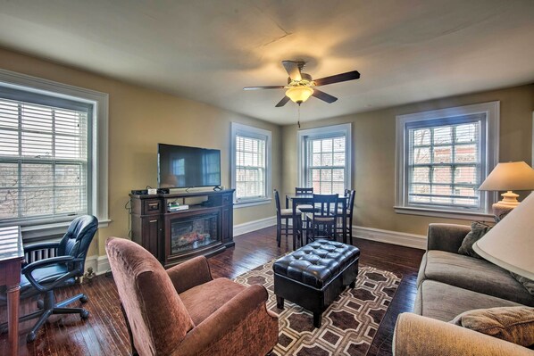 A living room with a fireplace, a ceiling fan, and a TV. - Walk to Shops, Dining & City Park: Reading Apt (Reading)