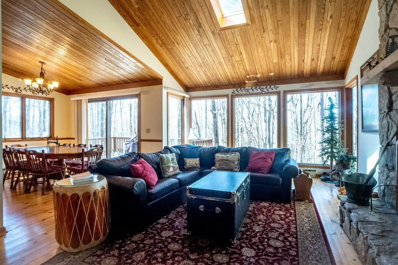 A spacious living room with a large sectional sofa, a dining table, and a fireplace.