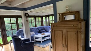 A room with a blue sofa, a white coffee table, and a wooden cabinet.