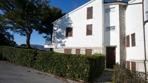 A white building with stone accents, a paved driveway, and a hedge. - M084 - Marcelli, three-room apartment with garden at Residence MareVerde (Marcelli)