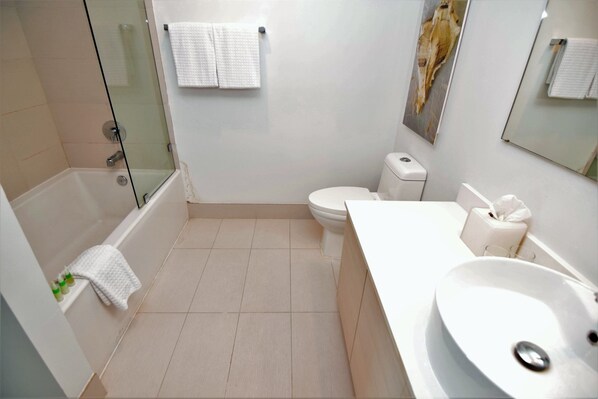 A modern bathroom with a bathtub, toilet, and sink.