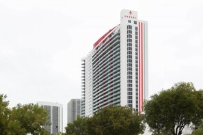 A tall hotel with a distinctive red and white striped pattern on its facade. - Ocean & Bay View Residence 1 Bed 1 Bath @ Beachwalk Hallandale Beach (Hallandale Beach)