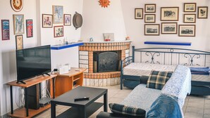 A living room with a TV, fireplace, and bed. - Naxos is the Way Summer Dream 1 apartment (Kastraki)