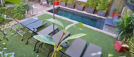 Una piscina al aire libre, una piscina climatizada, tumbonas