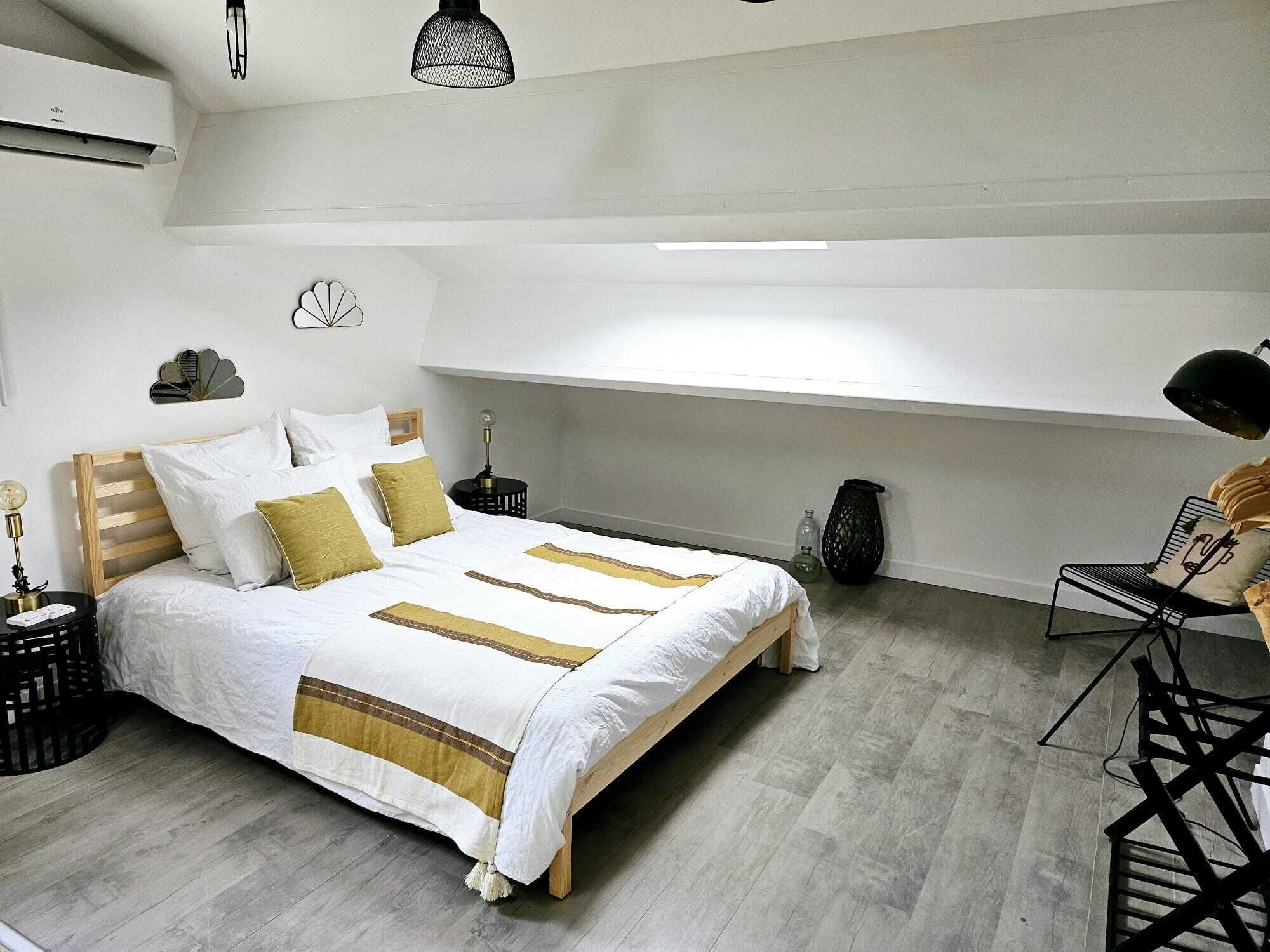 Un dormitorio moderno con cama de madera, ropa de cama blanca y un diseño minimalista.