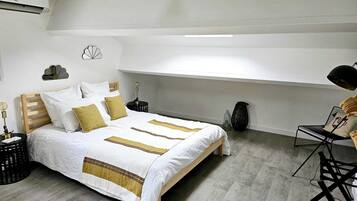 Un dormitorio moderno con cama de madera, ropa de cama blanca y un diseño minimalista.