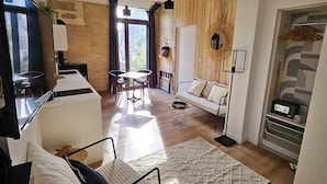 En moderne stue med sofa, spisebord og fjernsyn.