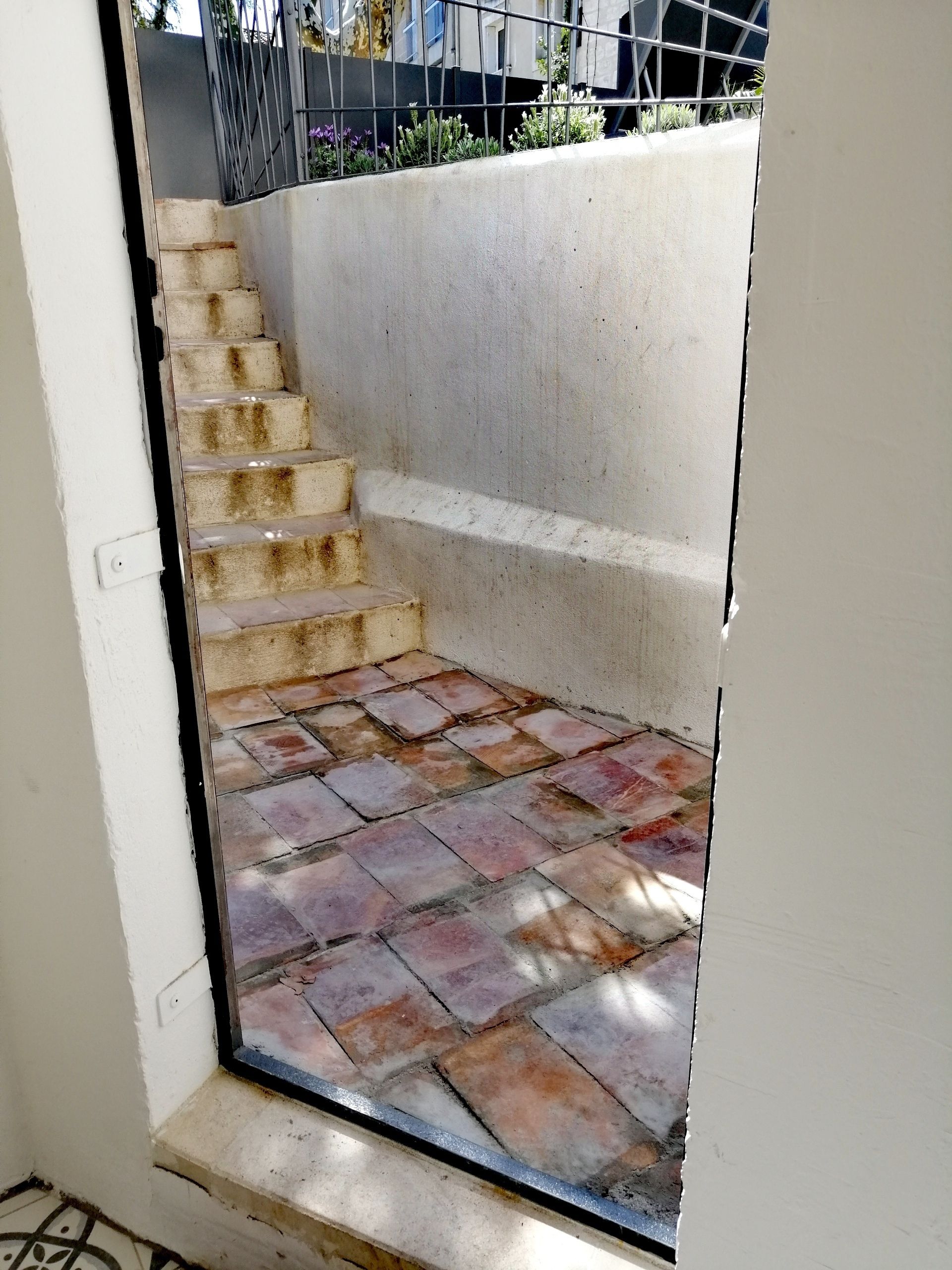 Un escalier en béton menant à une petite plateforme carrelée.