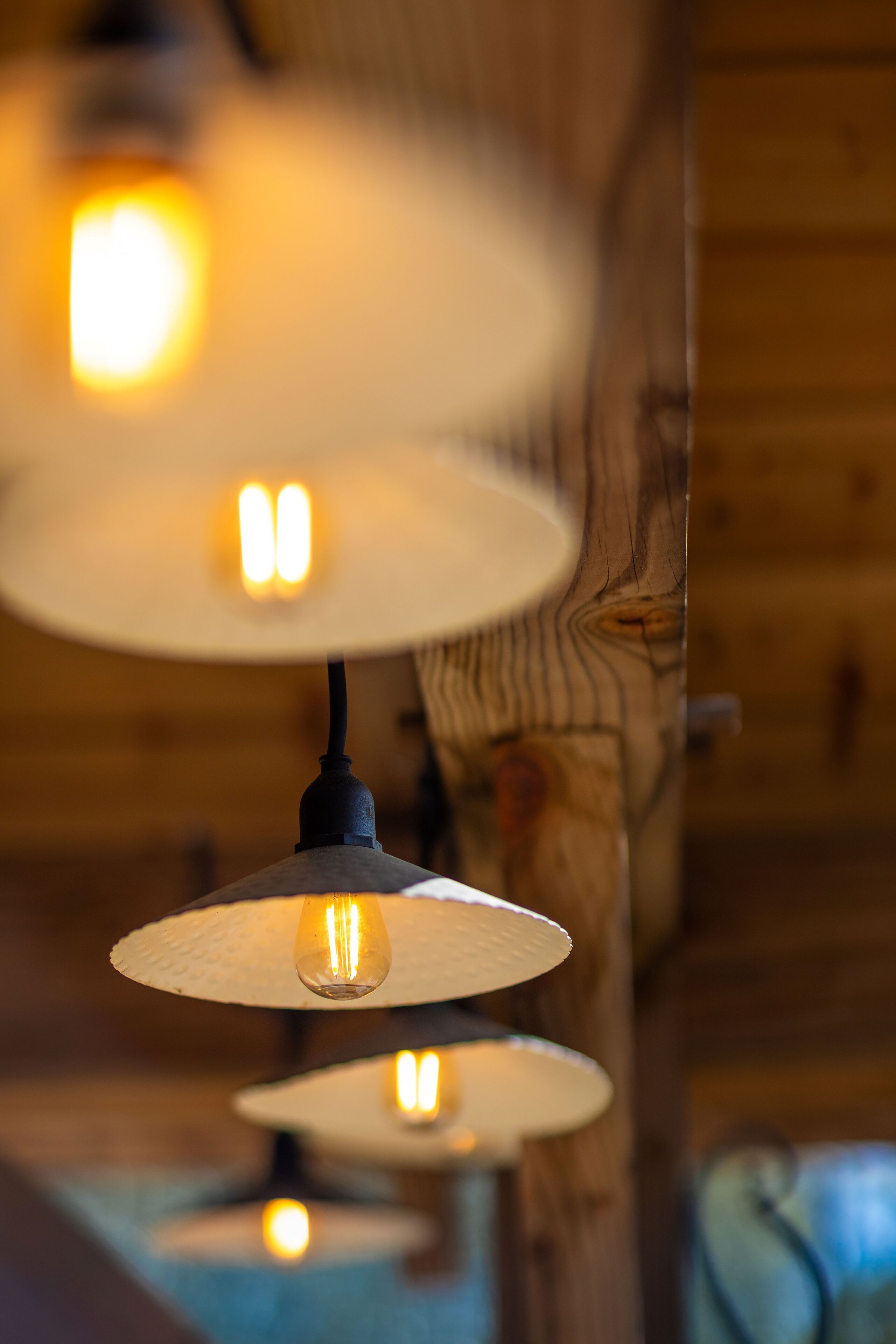A close-up of a wooden ceiling with three hanging lamps.