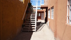 A narrow alleyway with a metal staircase leading to a building with barred windows. - Accommodation Tierras del sol (Entire House 2 bedrooms, close to the Center) (Las Heras)
