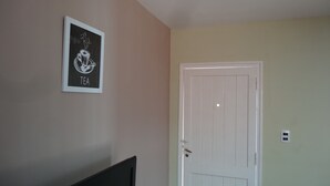 A room with a door, a framed picture on the wall, and a TV stand. - Accommodation Tierras del sol (Entire House 2 bedrooms, close to the Center) (Las Heras)
