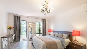 Ein Schlafzimmer mit einem Bett, Nachttischen, einem Schreibtisch und einem Stuhl.