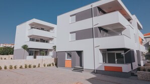 Un edificio moderno de varios pisos con techo plano, ventanas grandes y fachada de piedra.